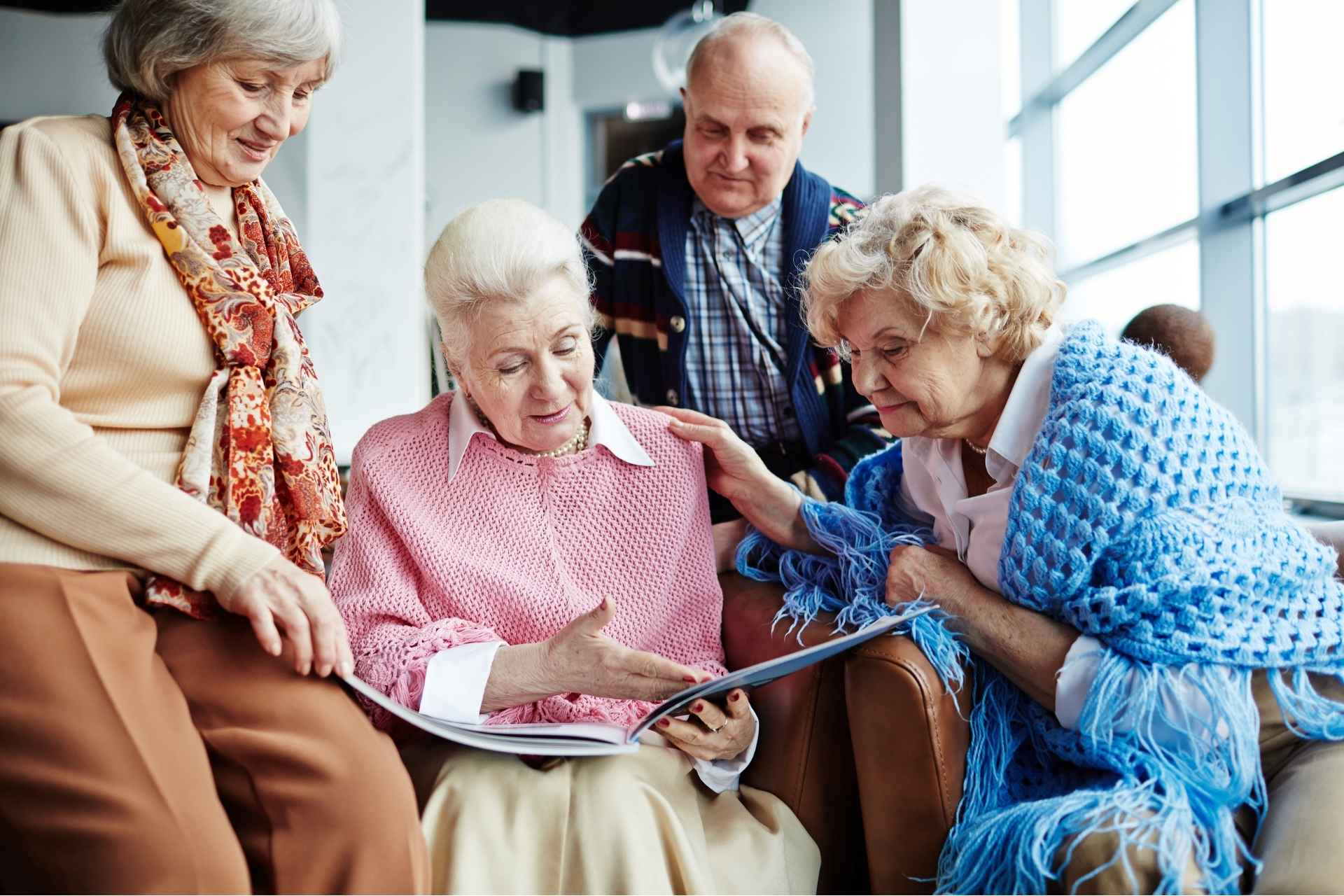 A group of seniors looking through a memory book.